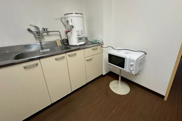 流し台と電子レンジが設置されたリゾートバイトの寮の共用キッチンの画像。