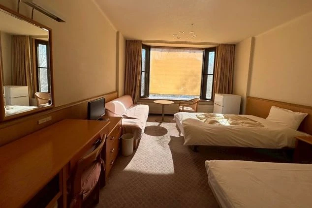 快適なリゾートバイト生活を支える、ソファとテレビ付きの広々とした個室寮の画像。