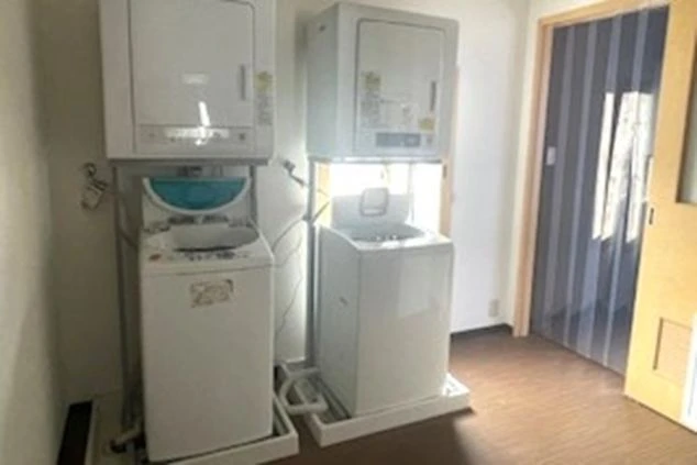 リゾートバイトの社員寮にある共用ランドリーのイメージ画像。洗濯機と乾燥機が複数台並んでいる。