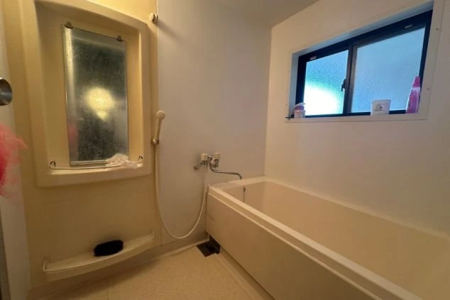 寮のお風呂。浴槽、シャワー、鏡、窓が映る清潔な空間。