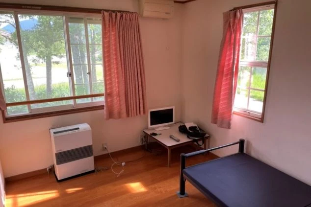 寮の個室。ベッド、テレビ、ストーブを完備。