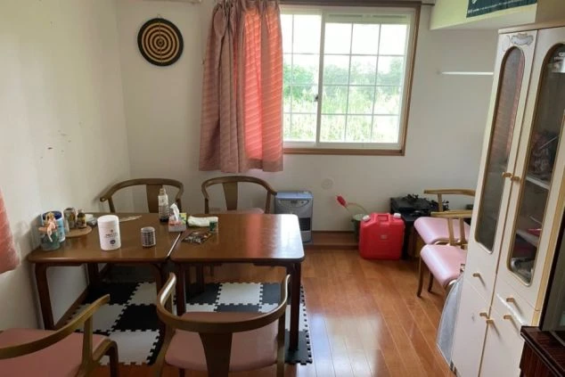 寮の部屋内。テーブルと椅子、収納家具を配置。