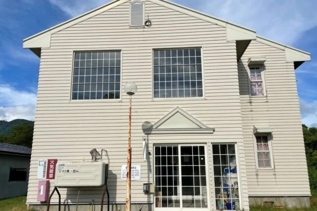 寮の外観。特徴的な窓を持つ2階建ての建物。