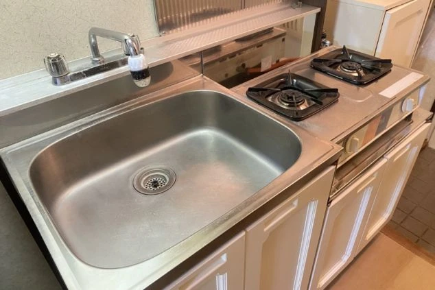 ワクトリの社員が出張で撮影した、リゾートバイトの寮のキッチンの画像。二口ガスコンロとステンレス製のシンクが一体になったコンパクトなキッチン。自炊が可能な設備が整っている。