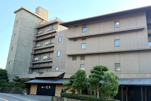 ホテルの一室の窓際に置かれた、木製のチェアが2脚写っている画像。窓の外には広大な海が広がっており、海を眺めながらゆったりと過ごすことができる。リゾートバイトのホテルや旅館の客室の画像。