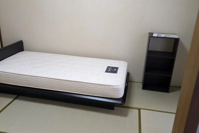 リゾートバイトの寮の和室。畳の部屋にベッドと棚が備え付けられており、和洋折衷の落ち着いた空間です。