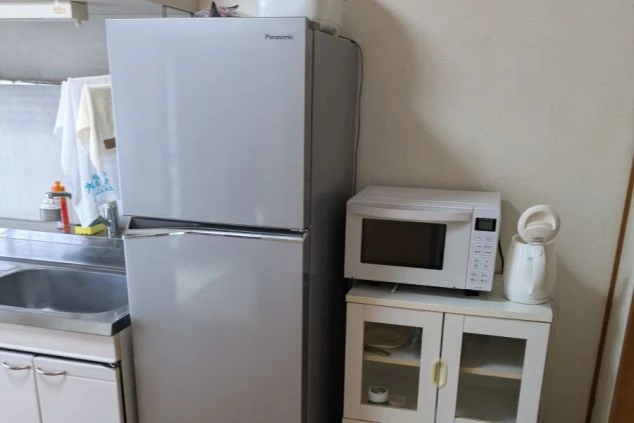 リゾートバイトの寮に備え付けの家電。冷蔵庫、電子レンジ、電気ケトルがあり、快適な寮生活をサポートします。
