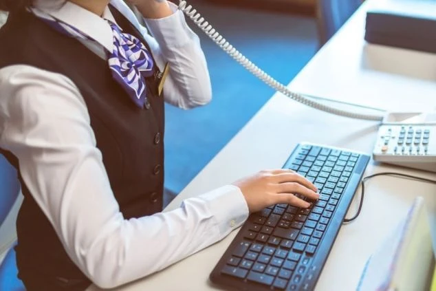 リゾートバイトの仕事風景を表現するイメージ画像。制服を着た女性が、電話対応やパソコン操作などの事務作業を行っている様子。