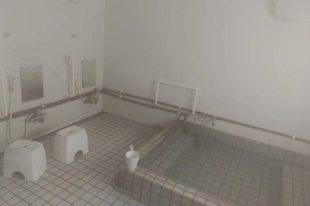 リゾートバイトの寮に備え付けられた共同風呂の画像。白いタイル張りの清潔感のある風呂場で、複数の人が同時に利用できるようになっている。リゾートバイトの寮の風呂場の画像。