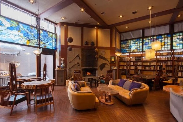 暖炉のあるホテルのラウンジの画像。木目調の落ち着いた雰囲気の部屋には、ソファーやテーブル、椅子が置かれている。リゾートバイトのホテルや旅館のロビーの画像。