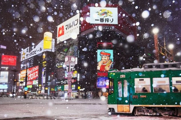 北海道札幌市にある札幌テレビ塔の画像。青空の下、赤と白のテレビ塔が緑の木々に囲まれて建っている。リゾートバイトの休日に観光を楽しめる、都会の風景の画像。