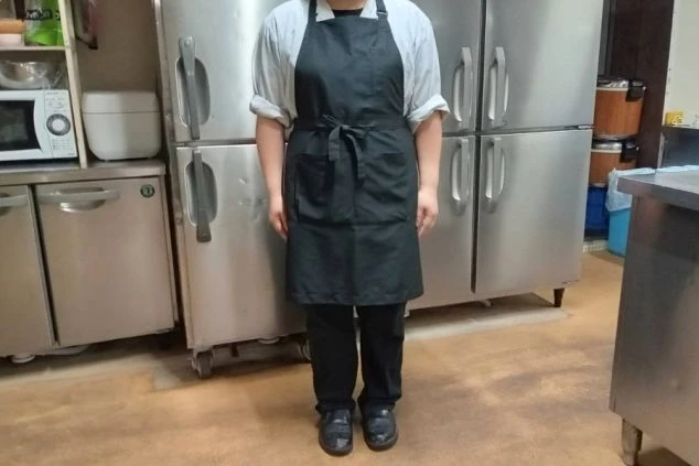 シャツにエプロンをした調理補助の制服画像。