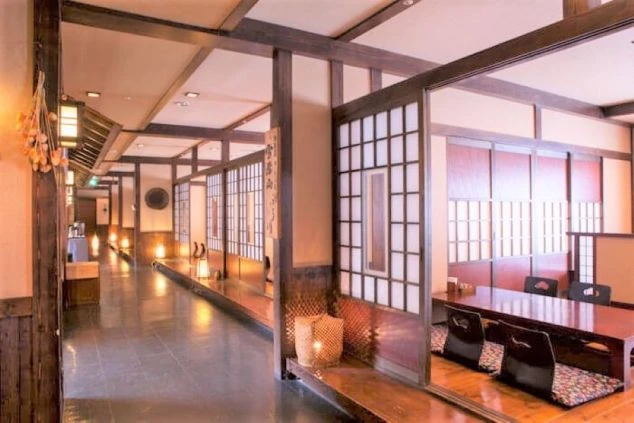 和風の落ち着いた雰囲気の食事処の画像。掘りごたつ式の個室が並び、廊下には温かい明かりが灯っている。リゾートバイトの仕事内容を表す、ホテルのダイニングの画像。