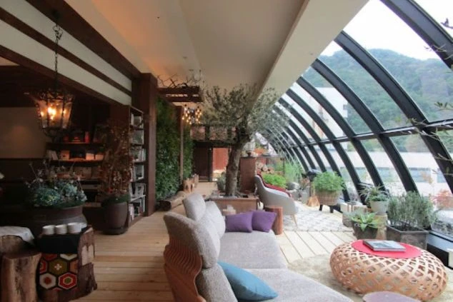 大きな窓から光が差し込む、開放的なホテルのラウンジの画像。木を基調とした部屋には、観葉植物やおしゃれなソファが置かれている。リゾートバイトの休憩時間や仕事終わりに利用できる、ホテルの共有スペース。