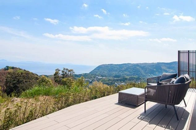 山と海を見下ろす開放的なテラスに置かれた、おしゃれなラウンジチェアの画像。