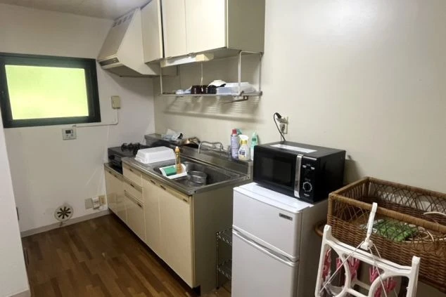 リゾートバイトの寮のキッチンの画像。ガスコンロ付きのシンクと冷蔵庫、電子レンジが備え付けられている。リゾートバイトの寮の設備の画像。
