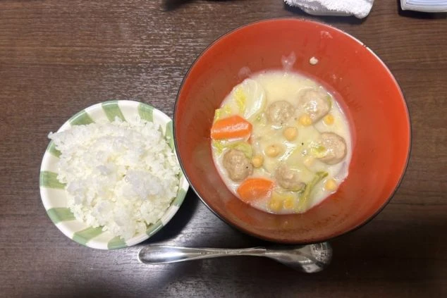 リゾートバイトの食事、まかないを表現するイメージ画像。鶏団子のクリームシチューとご飯。