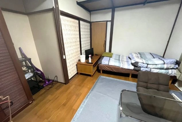 リゾートバイトの社員寮の部屋を表現するイメージ画像。テレビや布団が敷かれた和室。