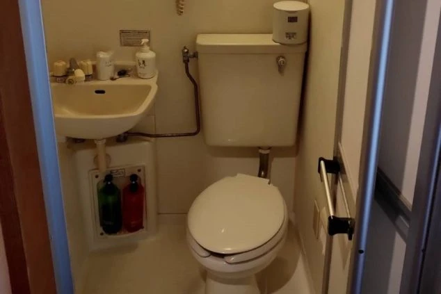 リゾートバイトの寮に備え付けられたユニットバスの画像。トイレと洗面台が一体となっており、シャンプーやボディソープが置かれている。リゾートバイトの寮の風呂場の画像。