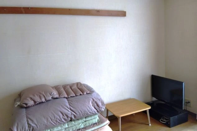 リゾートバイトの寮の部屋の一部を写した画像。布団と小さなテーブル、テレビが置かれている。リゾートバイトの寮の部屋の画像。