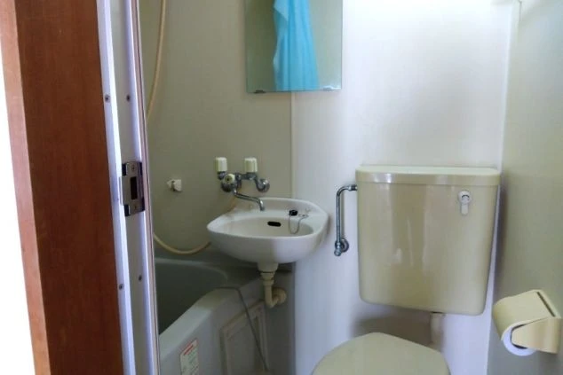 リゾートバイトの寮に備え付けられたユニットバスの画像。便座、洗面台、バスタブがまとまっており、清潔感がある。リゾートバイトの寮の風呂場の画像。