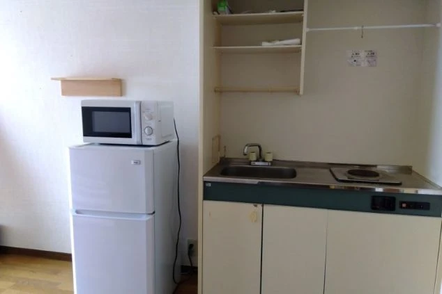 リゾートバイトの寮の部屋にあるキッチン。冷蔵庫と電子レンジ、IHクッキングヒーター付きのシンク。