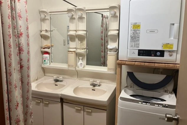 箱根のリゾートバイトの寮の洗面所の画像。洗濯機、乾燥機、洗面台を完備。