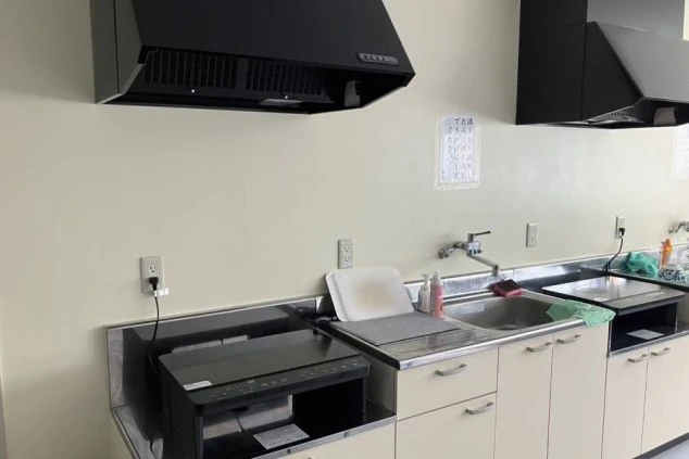 リゾートバイトの社員寮の部屋に備え付けられている家電のイメージ画像。冷蔵庫、電子レンジ、炊飯器が棚に置かれている。