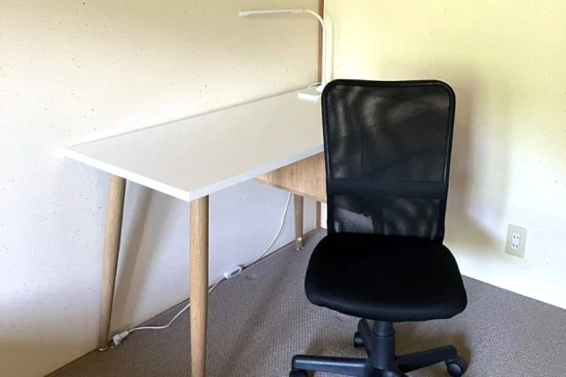 リゾートバイトの社員寮の部屋に備え付けられている家具のイメージ画像。広々とした机と椅子。