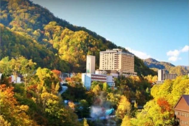 リゾートバイトの勤務先のイメージ画像。山間に建つホテルや旅館の、紅葉に彩られた秋の風景。