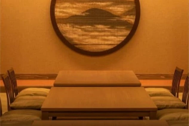 リゾートバイトの仕事風景を表現するイメージ画像。掘りごたつのようなテーブル席がある、旅館のレストランや宴会場。