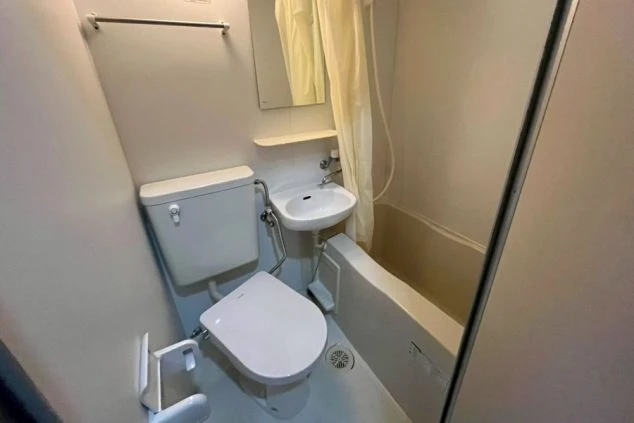 リゾートバイトの個室寮にあるユニットバス。浴槽、洗面台、温水洗浄便座付きのトイレが一体となった、清潔な設備の画像。