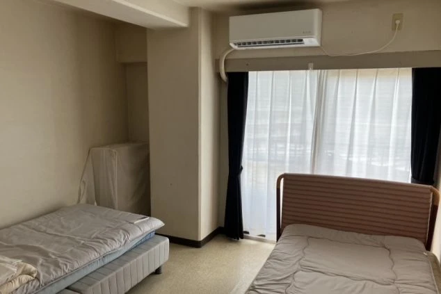 リゾートバイトの相部屋寮の室内。シングルベッドが2つ置かれ、エアコンも完備されている、友人やカップルでのリゾートバイトに最適な部屋の画像。