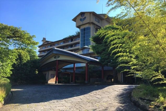 静岡の旅館の外観の画像。瓦屋根の入り口と、木々に囲まれた風情のある建物である。リゾートバイトの仕事内容を表す、ホテルや旅館の外観の画像。