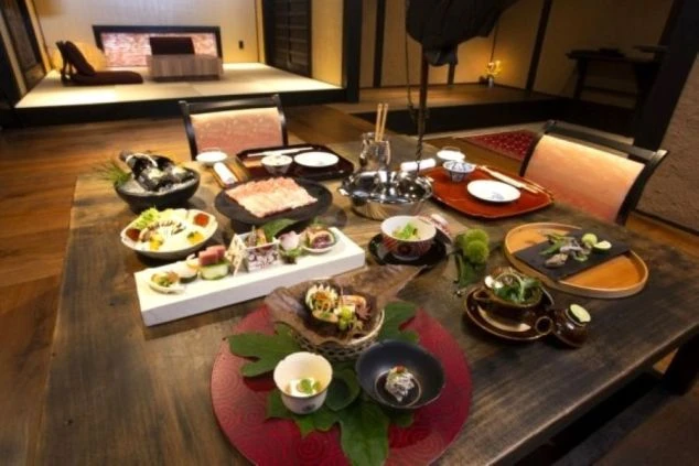 旅館のモダンな共用スペース。間接照明と木製の階段がある、おしゃれな内装の施設で働く仕事募集。