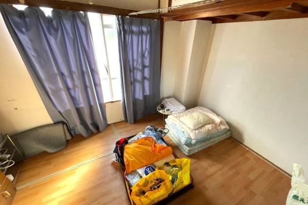 ワクトリでリゾートバイトをするスタッフが撮影した、静岡県下田でのリゾートバイトの寮の画像。寝具が用意されている。部屋の中心には、スタッフのスーツケースが広がっている。