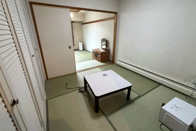 テーブルとヒーターが設置され、奥にはもう一部屋見える。