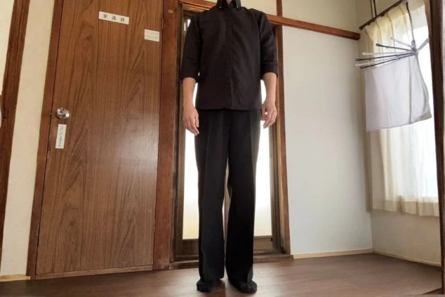 シックな黒のシャツとスラックスを組み合わせた、モダンな館内全般業務用の制服画像。