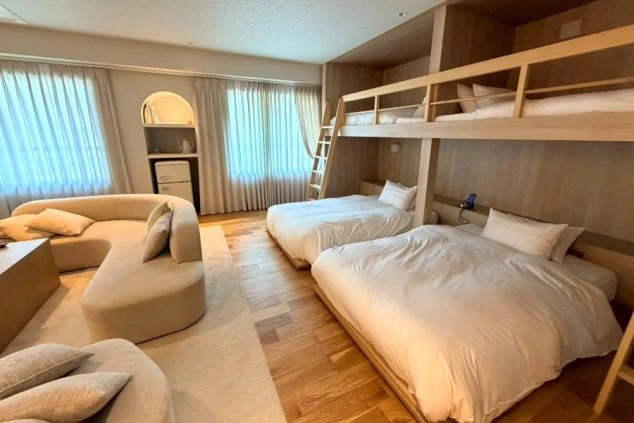 オーシャンビューのリゾートホテルの客室の画像。ベッドとソファが置かれた広々とした部屋で、窓の外には海が広がっている。