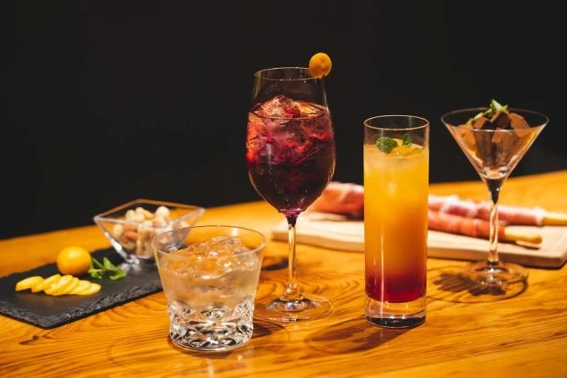 おしゃれなカクテルと前菜。リゾートバイトで働けるホテルのバーで提供されるドリンクと食事のイメージ画像。