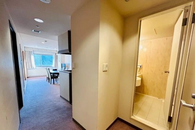 リゾートバイト生活をサポートする、清潔で機能的な寮の部屋。奥にはリビング、手前にはトイレがあり、快適に過ごせる。