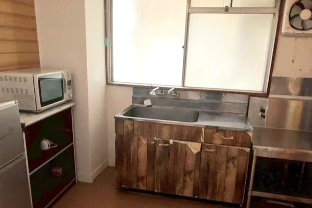 リゾートバイト寮の室内キッチン。冷蔵庫や電子レンジ完備で、休日や仕事終わりも自由に自炊ができる便利な生活環境。