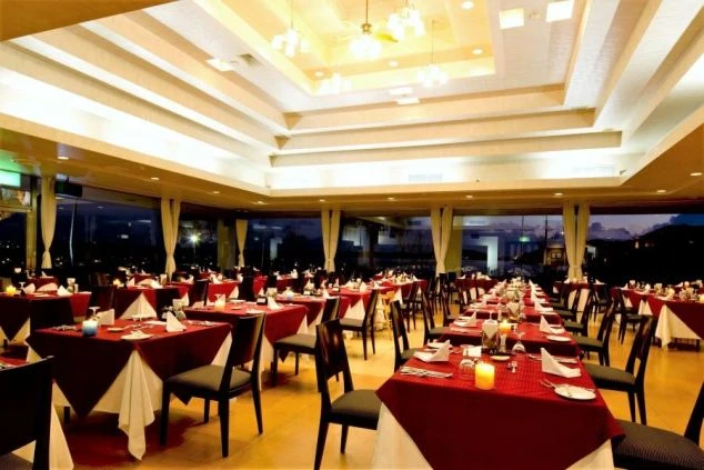 ホテルのレストランのダイニングの画像。たくさんのテーブルが並び、赤色のクロスと白いナプキンが上品な雰囲気を醸し出している。リゾートバイトの仕事内容を表す、ホテルのダイニングの画像。