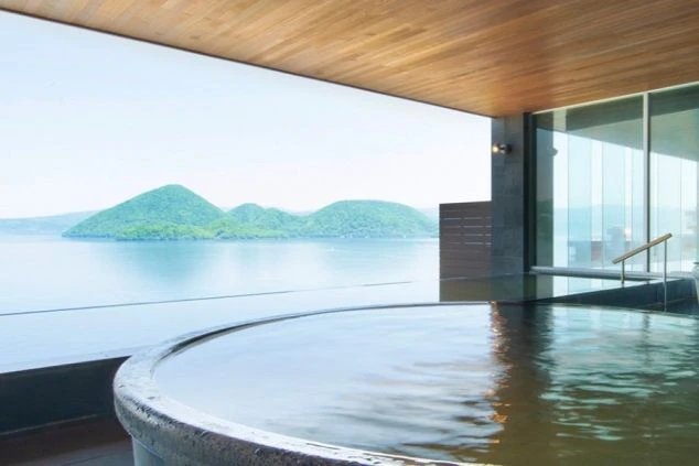 大きな窓から湖の絶景が一望できる、露天風呂の画像。リゾートバイトの寮やホテルの福利厚生としても利用できる、温泉の画像。
