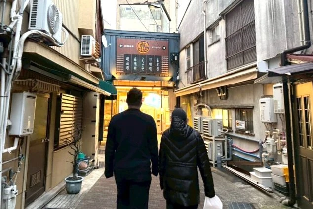 木々に囲まれたモダンな建物の外観と、手前に広がる豊かな緑。