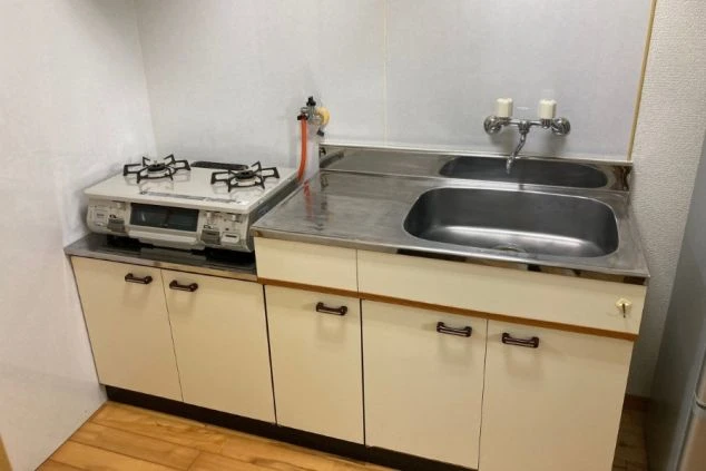 リゾートバイトの寮のキッチンの画像。ガスコンロとシンクが一体になったシステムキッチンで、調理に便利な設備が整っている。