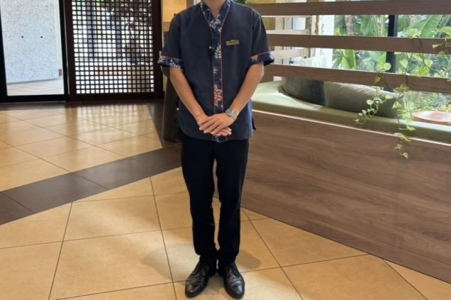 リゾートバイトの仕事風景を表現するイメージ画像。沖縄らしい花柄のシャツを着用した男性。