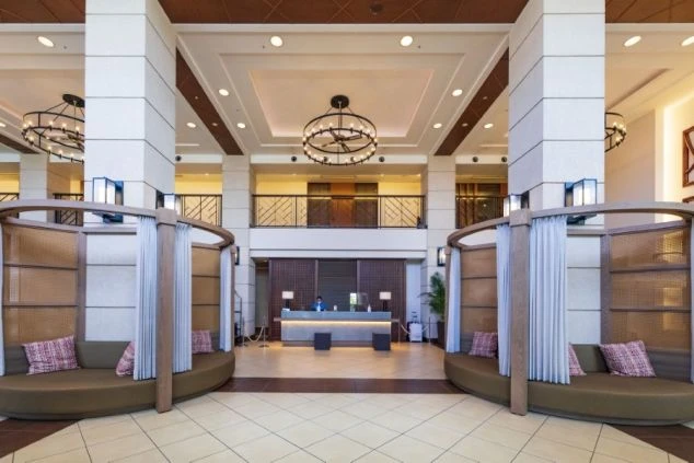 ホテルの受付カウンターと、くつろげるソファスペースが広がる開放的な空間。