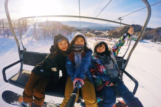 リフトに乗って笑顔を見せる若者たち。リゾートバイトの仲間と、オフの日には一緒に雪山を満喫しませんか。