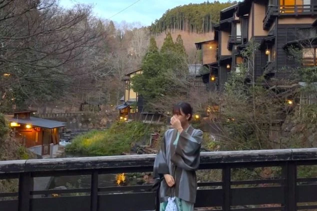 温泉街の風情ある橋に立つ浴衣姿の女性。リゾートバイトで、非日常の体験をしてみませんか。